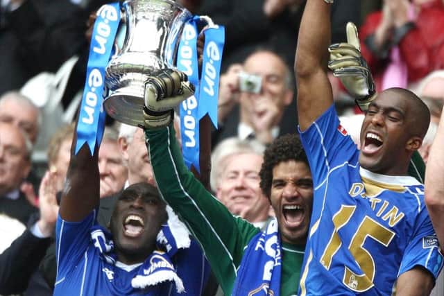 Sol Campbell, left, lifts the FA Cup with David James, centre, and  Sylvain Distain after Pompey's 1-0 victory against Cardiff City in 2008.