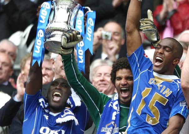 Sol Campbell, left, lifts the FA Cup with David James, centre, and  Sylvain Distain after Pompey's 1-0 victory against Cardiff City in 2008.