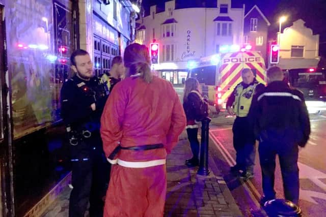 Police talk to a reveller dressed as Santa
