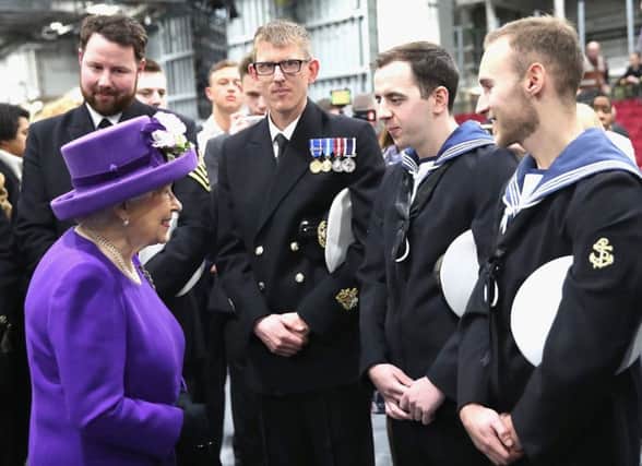 Queen Elizabeth II talks to members of the ship's company, during the commissioning of HMS Queen Elizabeth, Britain's biggest and most powerful warship, into the Royal Navy Fleet at Portsmouth Naval Base Credit: Chris Jackson/PA Wire