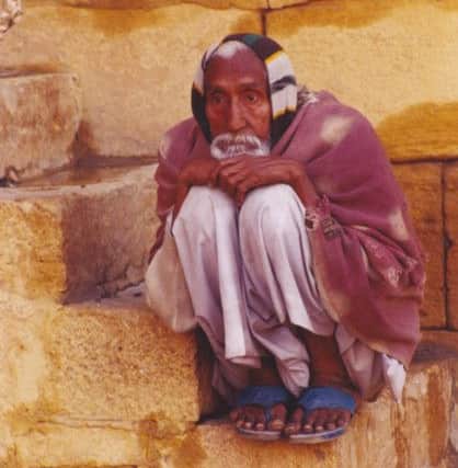Perched like a bird on a step, an old man watches street life in Jaisalmer, Rajasthan (Picture: Trevor Fishlock)
