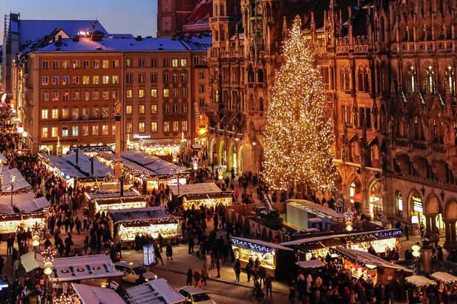 The Neues Rathaus and the Frauenkirche, in the background, illuminated by Munich Christmas Market at the Marienplatz.