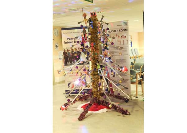 Staff at Queen Alexandra Hospital Fracture and Orthopaedic Clinic raise awareness of osteoporosis with their special Christmas tree made from walking crutches