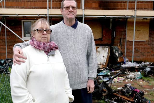 Angela Whinham and her partner, David Thorn outside their house in Gosport with the remains ofdebris from the fire
