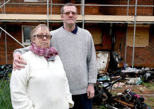 Angela Whinham and her partner, David Thorn outside their house in Gosport with the remains ofdebris from the fire