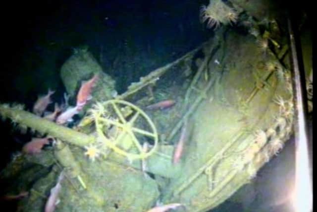 In this undated image provided by the Australian Department of Defense, fish swim around the helm of the Australian submarine HMAS AE1 off the coast of the Papua New Guinea island of New Britain