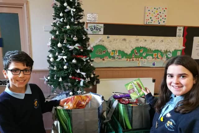 Copnor Primary School head boy Bawer Omar and head girl Mia Mai Antar make up food parcels at North End Baptist Church