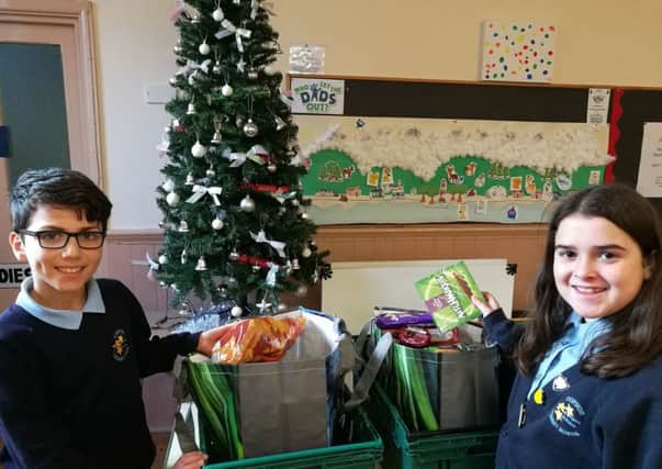 Copnor Primary School head boy Bawer Omar and head girl Mia Mai Antar make up food parcels at North End Baptist Church