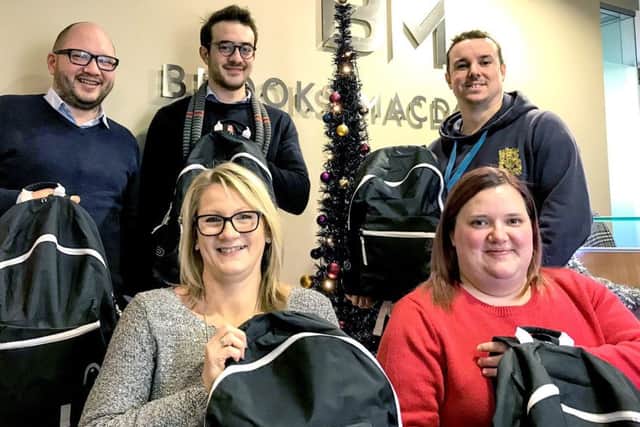 Brooks Macdonald donated rucksacks to Portsmouth charity The Lifehouse. Pictured (back row) Russell Leggatt, Sami Kassou and James Place and (front row) Sally Spicer and Lizzie Cole