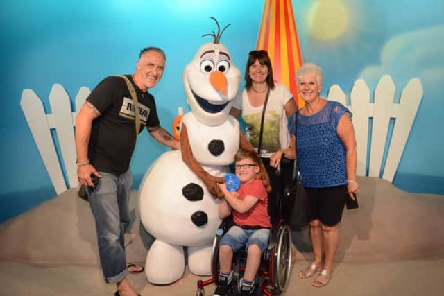 Finlay Lyons, eight, meets Olaf the snowman from Frozen,  with his parents Carly and Scott and his grandma Barb Horsfall