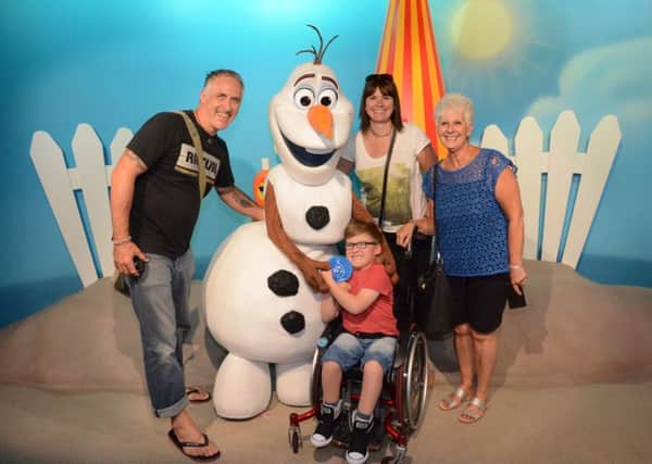 Finlay Lyons, eight, meets Olaf the snowman from Frozen,  with his parents Carly and Scott and his grandma Barb Horsfall