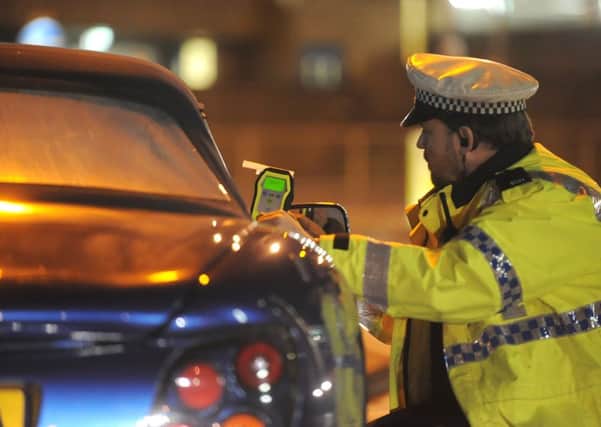 An officer stops a suspected drink-driver for a breath test