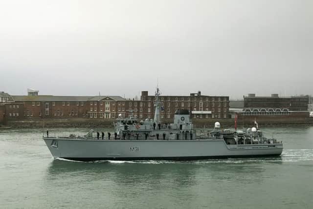 The company of HMS Cattistock line the deck as the ship leaves Portsmouth