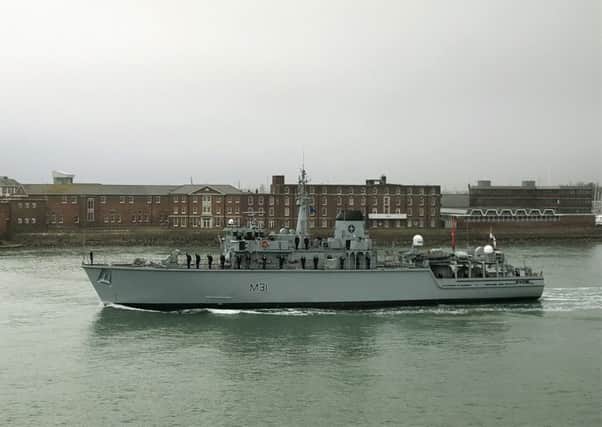 The company of HMS Cattistock line the deck as the ship leaves Portsmouth