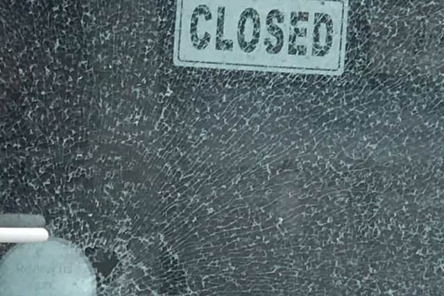 The smashed glass in the door at Johnny Black Photography in Southsea
