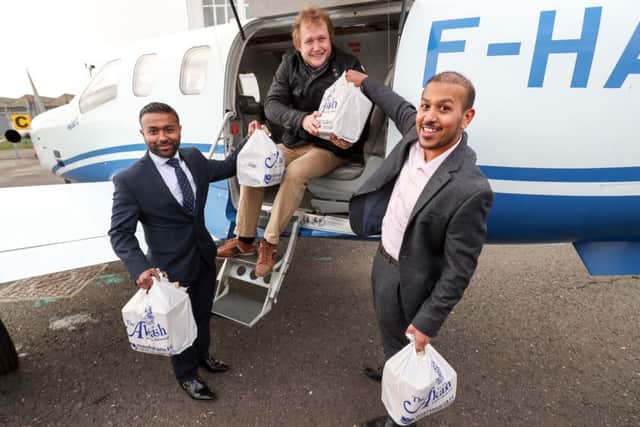 Brothers Faz, right, and Jaf Ahmed from the Akash restaurant in Southsea help James Emery load a curry takeaway onto a plane at Solent Airport so it can be flown to France for the British ex-pat and his friends at Saucats Airfield, south of Bordeaux Picture: Andrew Matthews/PA Wire