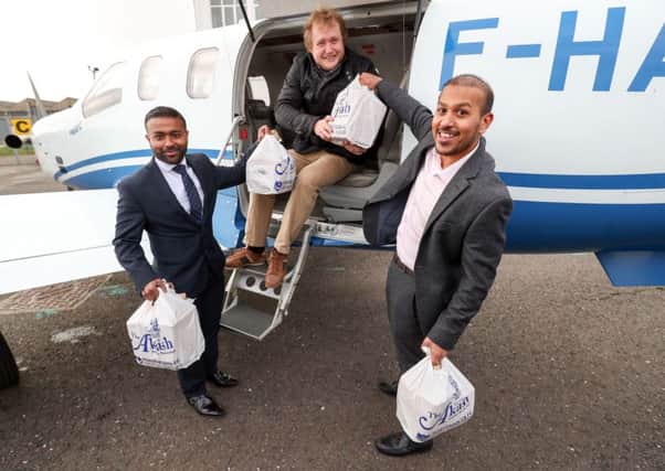 Brothers Faz, right, and Jaf Ahmed from the Akash restaurant in Southsea help James Emery load a curry takeaway onto a plane at Solent Airport so it can be flown to France for the British ex-pat and his friends at Saucats Airfield, south of Bordeaux Picture: Andrew Matthews/PA Wire