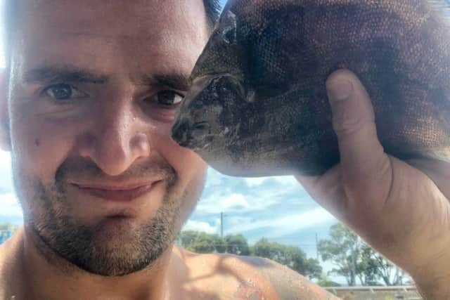 Russell Hogg holding the flounder which fell on his face at Parnell Swimming Baths in Auckland