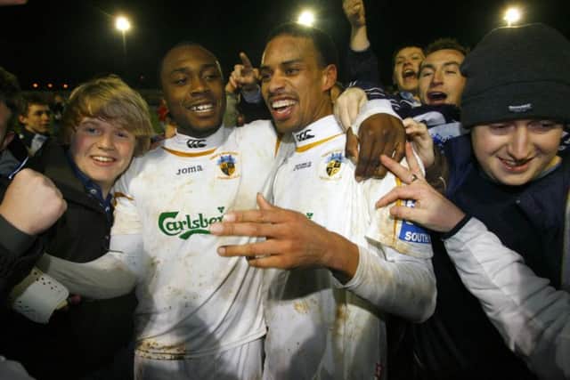 Richard Pacquette and Rocky Baptiste (right) celebrate with the Hawks fans after the win against Swansea