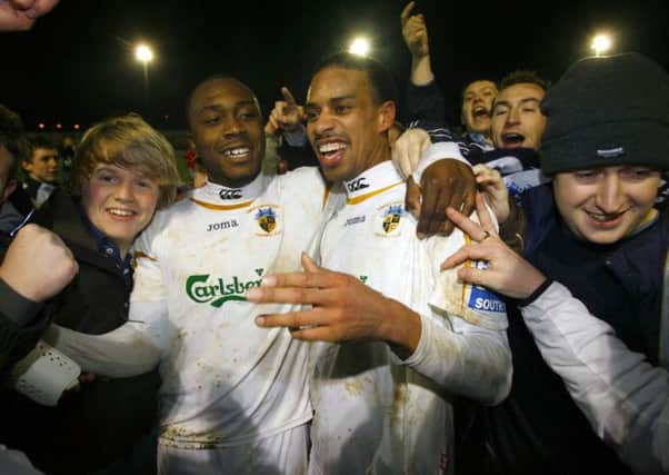 Richard Pacquette and Rocky Baptiste (right) celebrate with the Hawks fans after the win against Swansea