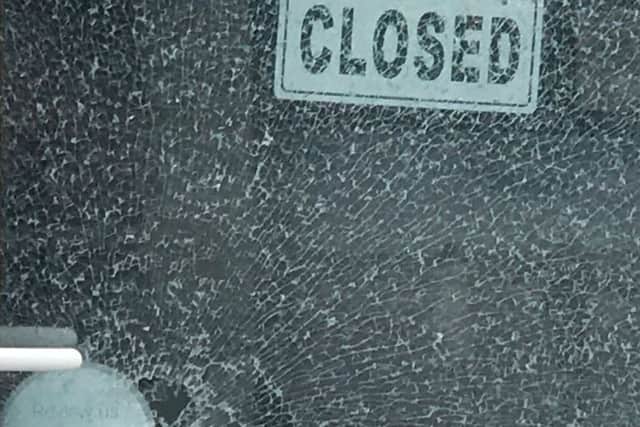 The smashed glass in the door at Johnny Black Photography in Southsea