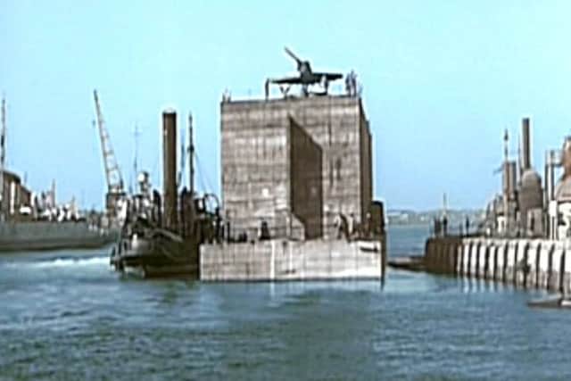 In the tidal basin of Portsmouth dockyard is a section of the Mulberry Harbour just leaving North Wall in 1944. Picture courtesy Mike Nolan 	  mmm
