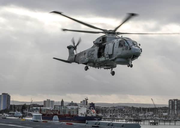 A Merlin helicopter from Royal Naval Air Station Culdrose has been training with HMS Queen Elizabeth in Portsmouth Naval Base as part of her Rotary Wing Trials