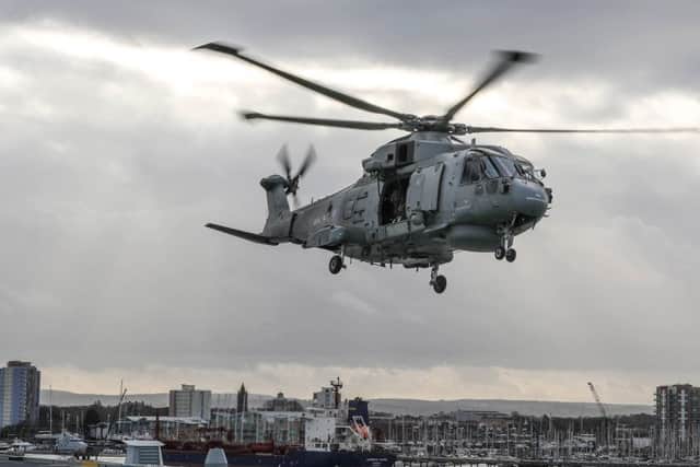 A Merlin helicopter from Royal Naval Air Station Culdrose has been training with HMS Queen Elizabeth in Portsmouth Naval Base as part of her Rotary Wing Trials