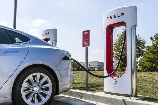 A car powers up at a Tesla Supercharger