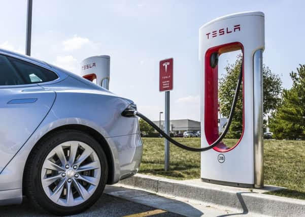 A car powers up at a Tesla Supercharger