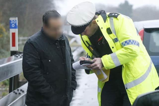 Police question a suspect at the roadside as part of the operation targeting drivers illegally using mobile phones
Picture: Habibur Rahman