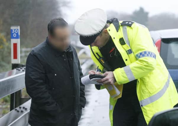 Police question a suspect at the roadside as part of the operation targeting drivers illegally using mobile phones

Picture: Habibur Rahman