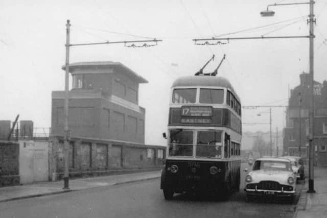 A trolleybus on The Hard passing the now-redundant signal box outside Portsmouth Harbour station.