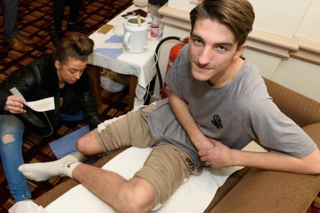Lewis Amey (Jo's grandson) supports Jo through a sponsored lag wax
Picture: Duncan Shepherd (180089_005)