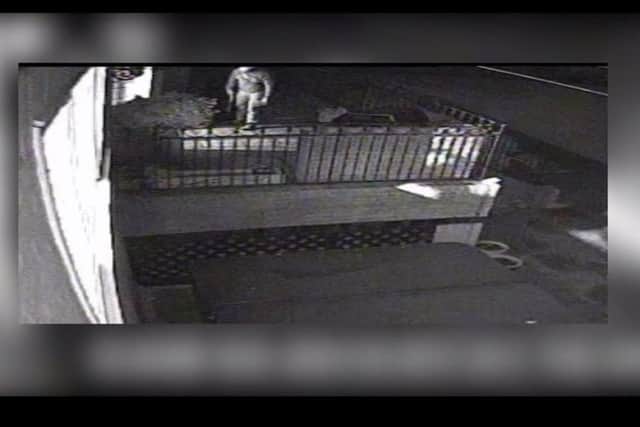 The burglar gets ready to enter a property with a sawn-off shotgun. CCTV footage released by Surrey Police