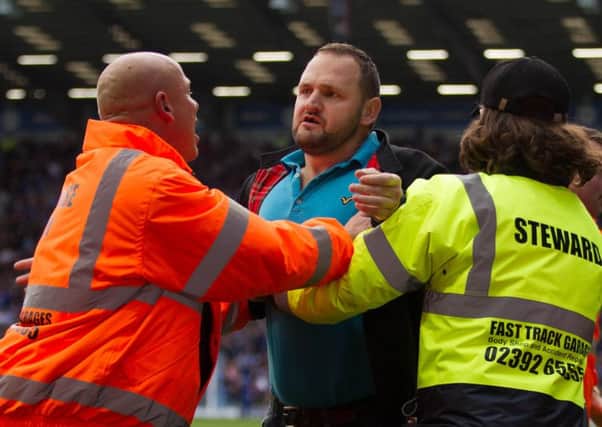 Wesley Young being held back by stewards at Fratton Park. Picture: Dave Taylor