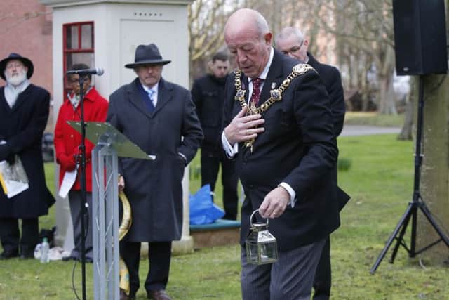 Mayor Ken Ellcome places a candle near the memorial to Anne Frank Picture: Habibur Rahman (180167-550)
