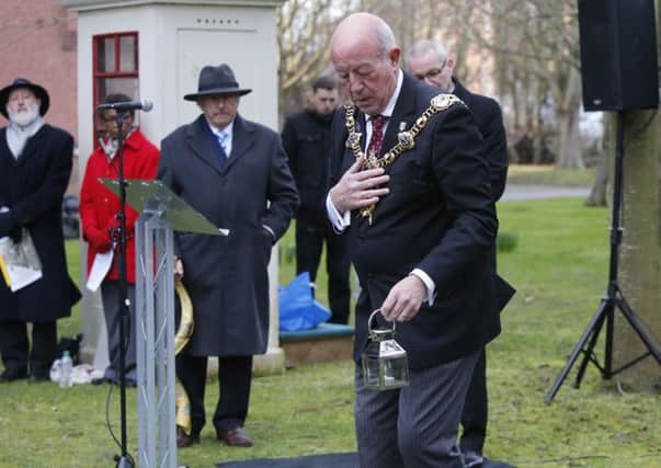 Mayor Ken Ellcome places a candle near the memorial to Anne Frank Picture: Habibur Rahman (180167-550)