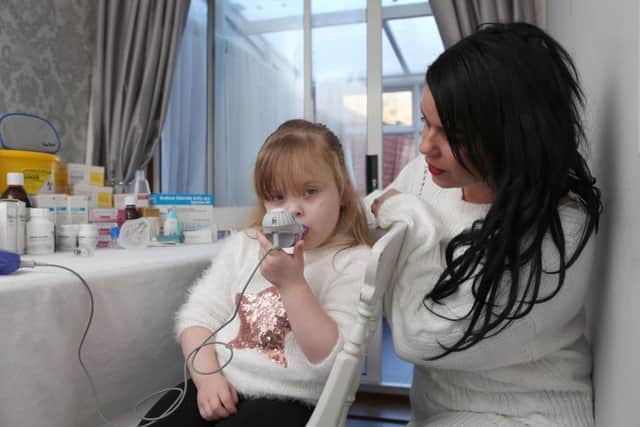 Ivy Weir undergoing nebuliser treatment with her mum Gemma