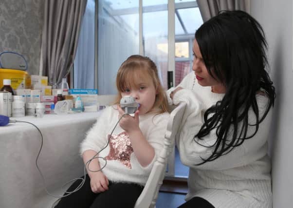 Ivy Weir undergoing nebuliser treatment with her mum Gemma