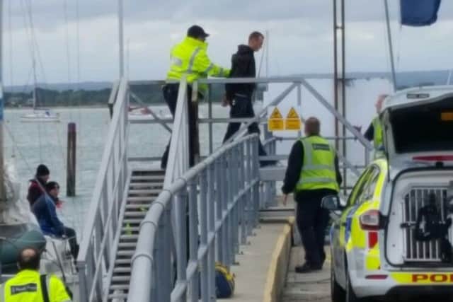 An unidentified man being led from a Border Force vessel at Sparkes Marina in Hayling Island in May 2017. Picture: Tanya Farne
