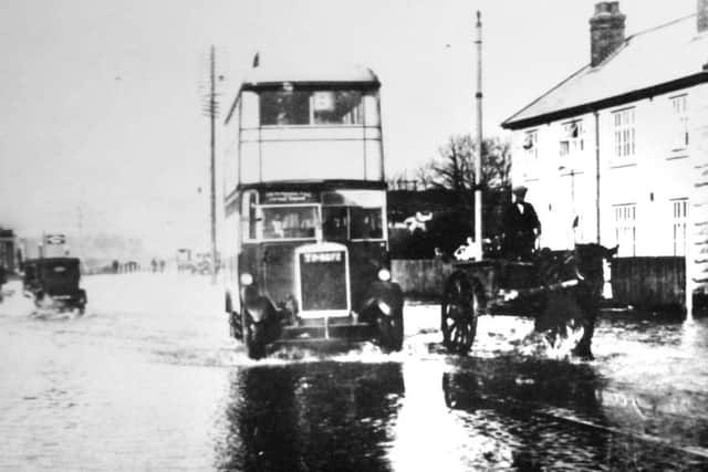 Ploughing through flood water at Hilsea in the 1920s, a bus travels south leaving a wake.