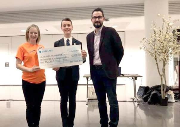 Ed Ditcham, 13, presents a cheque to representatives from Alzheimer's Research UK