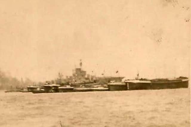 An aircraft carrier and munition barges in the northern reaches of Portsmouth Harbour.