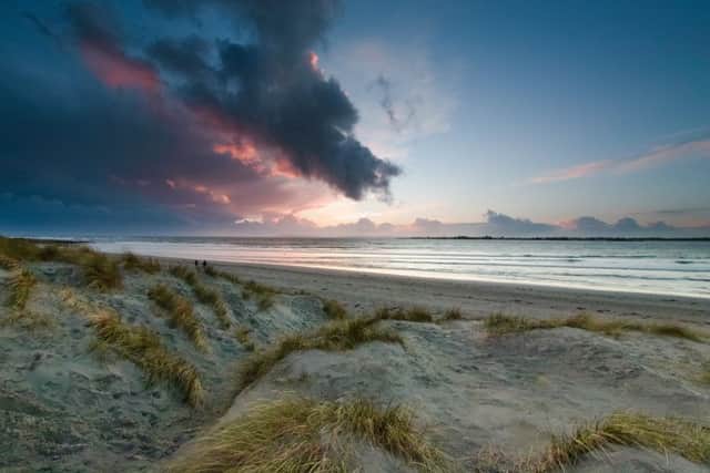 Stormy clouds with sun rays just before sunset on a winters day at West Head on West Wittering Beach
