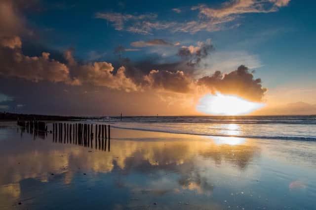 Stormy clouds with sun rays just before sunset on a winters day at West Head on West Wittering Beach