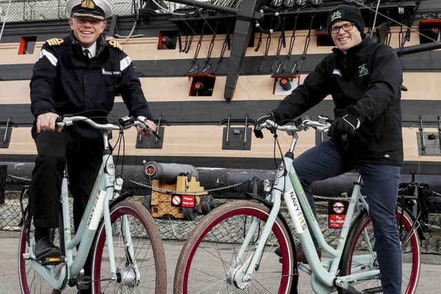 Left to right is Captain Oliphant of HMNB Portsmouth and Charlie Adie, the CEO of Motive in front of HMS VICTORY with some of the new NavyFit loan bike