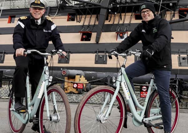 Left to right is Captain Oliphant of HMNB Portsmouth and Charlie Adie, the CEO of Motive in front of HMS VICTORY with some of the new NavyFit loan bike