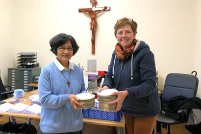 Sister Maura, pastoral assistant at Portsmouth Catholic Cathedral, donating the Bishops Plates to City of Portsmouth Charitable Friends volunteer Tracy McClure