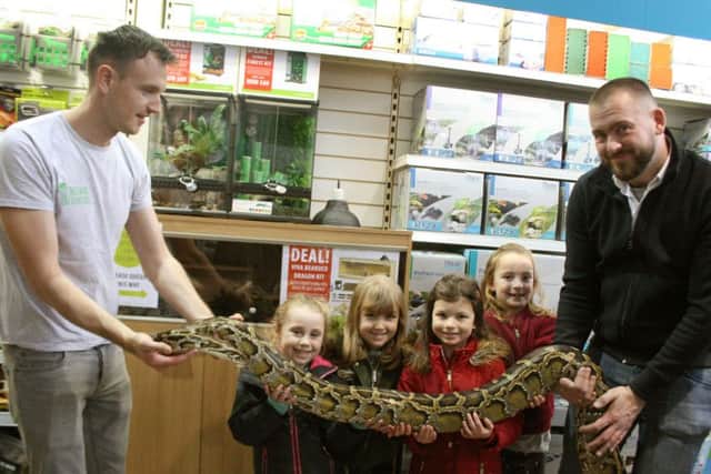 Eevie Reid, Ellie Hacket, Rosie Rogers and Imogen Quade have a close encounter with a Burmese python held by Tom Charlton from Eco Animal Encounters, left, and Sam Baker, managing director of Aquajardin at a reptile event at Garssons